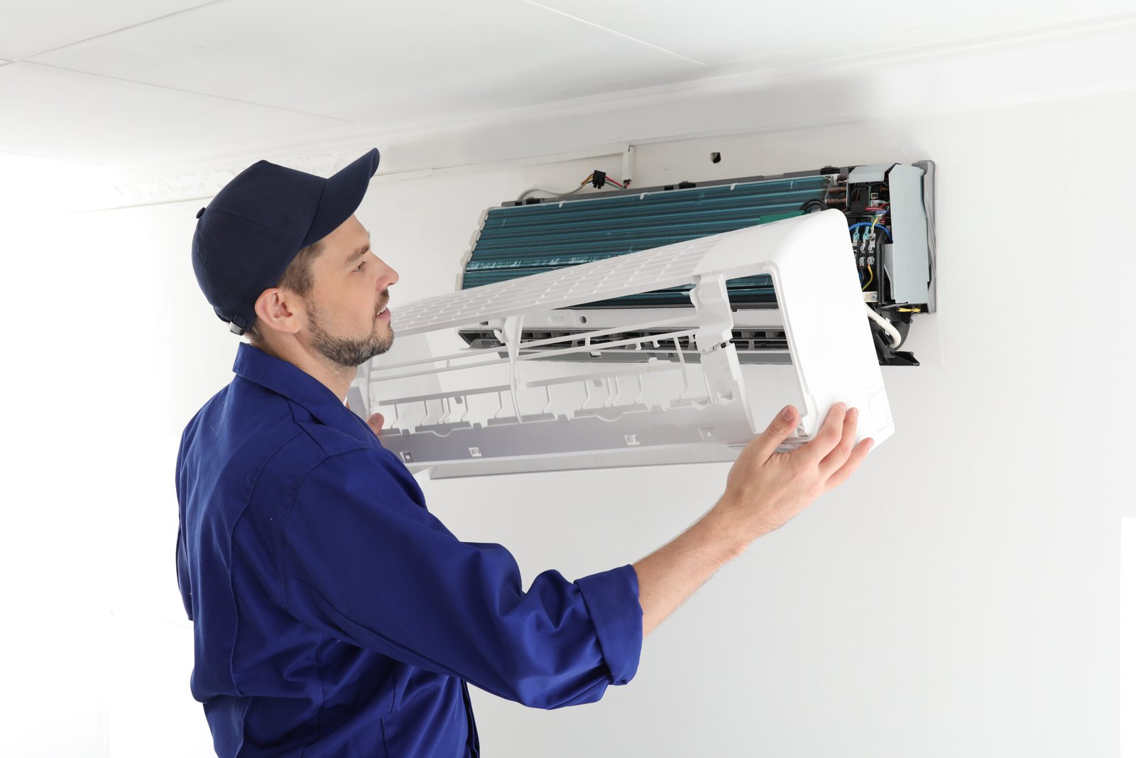 Male technician repairing air conditioner indoors